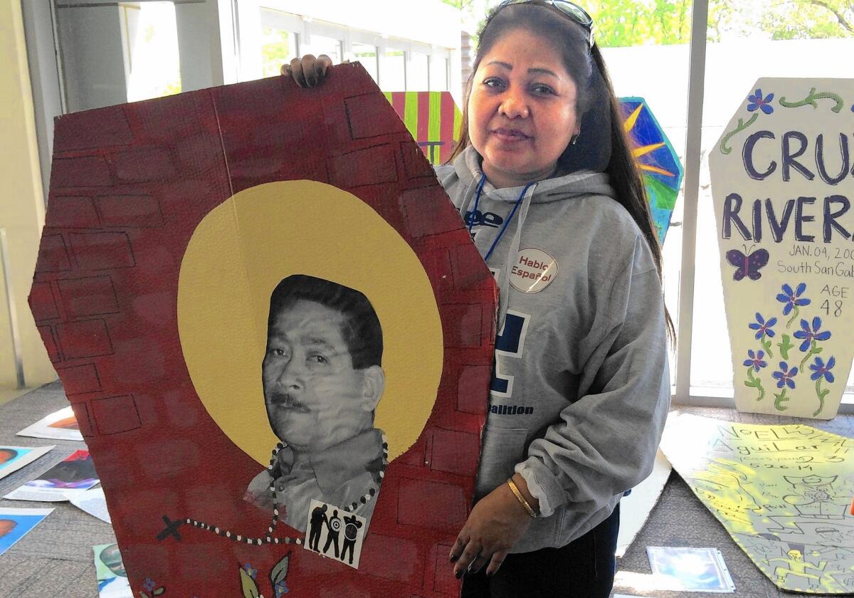 Albania Morales holds a placard bearing a picture of her late husband at a criminal justice conference in Sacramento.