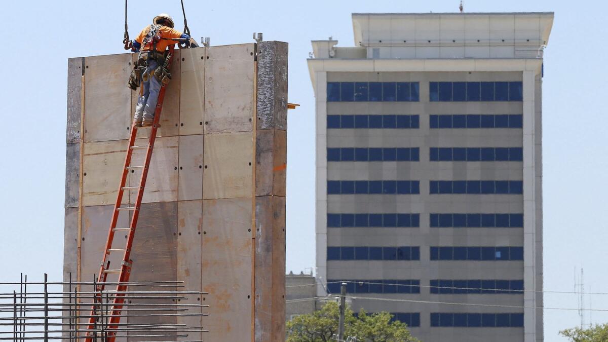 A construction worker removes crane cables from a concrete wall in Gulfport, Miss.