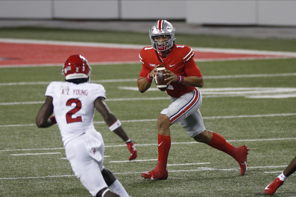 Ohio State quarterback Justin Fields, right, looks for an open receiver as Rutgers defensive back Avery Young defends during the first half of an NCAA college football game Saturday, Nov. 7, 2020, in Columbus, Ohio. (AP Photo/Jay LaPrete)