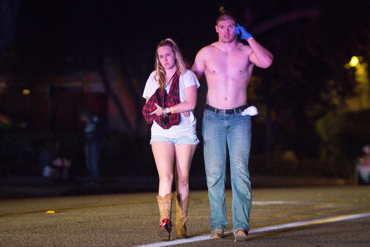 A couple walk up Rolling Oaks Drive following the shooting.