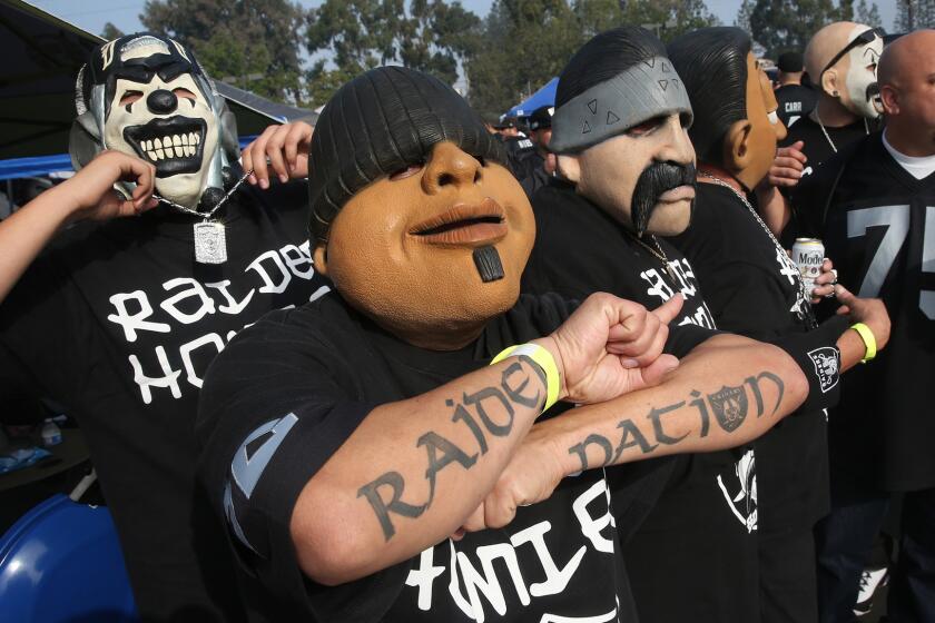 Gonzalo Gonzalez flashes a "Raider Nation" tattoo as he and others promoting Homies toys parade around the tailgating lot at Stubhub Center. Hundreds of Raiders fans lined up very early to set up tents and barbecues before the Chargers-Raiders game.