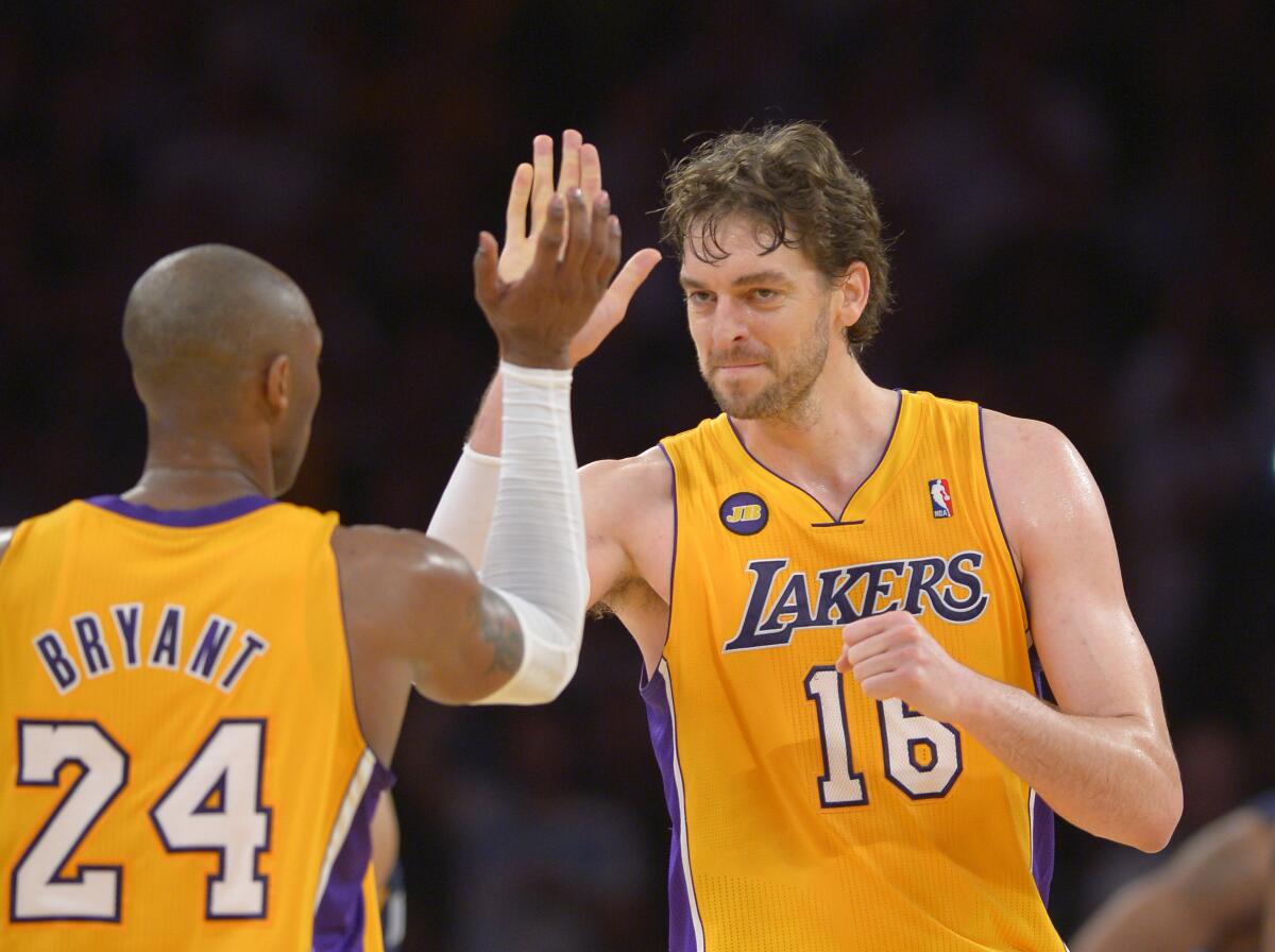 Lakers forward Pau Gasol and teammate Kobe Bryant high-five during a game in 2013.
