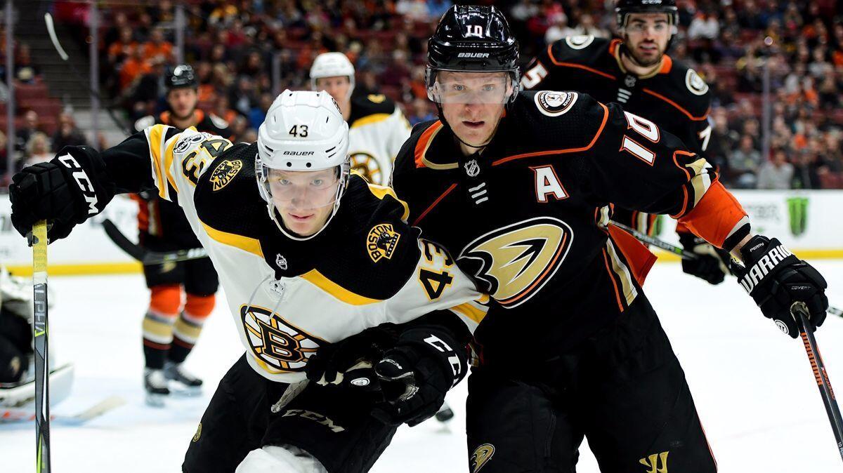 Boston Bruins' Danton Heinen (43) and Ducks' Corey Perry (10) skate after the puck during the second period at Honda Center on Wednesday.