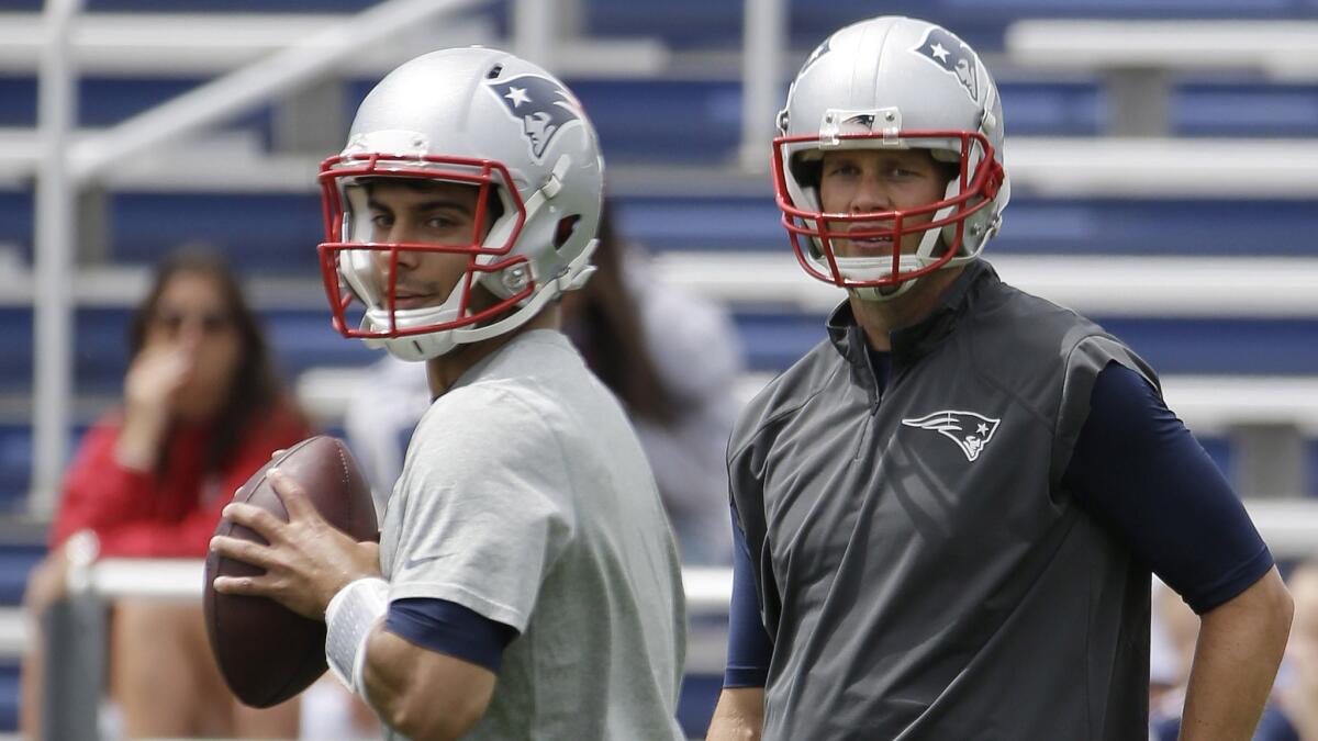 New England Patriots backup quarterback Jimmy Garoppolo drops back to pass in front of quarterback Tom Brady during a minicamp training session in Foxborough, Mass., on June 17.