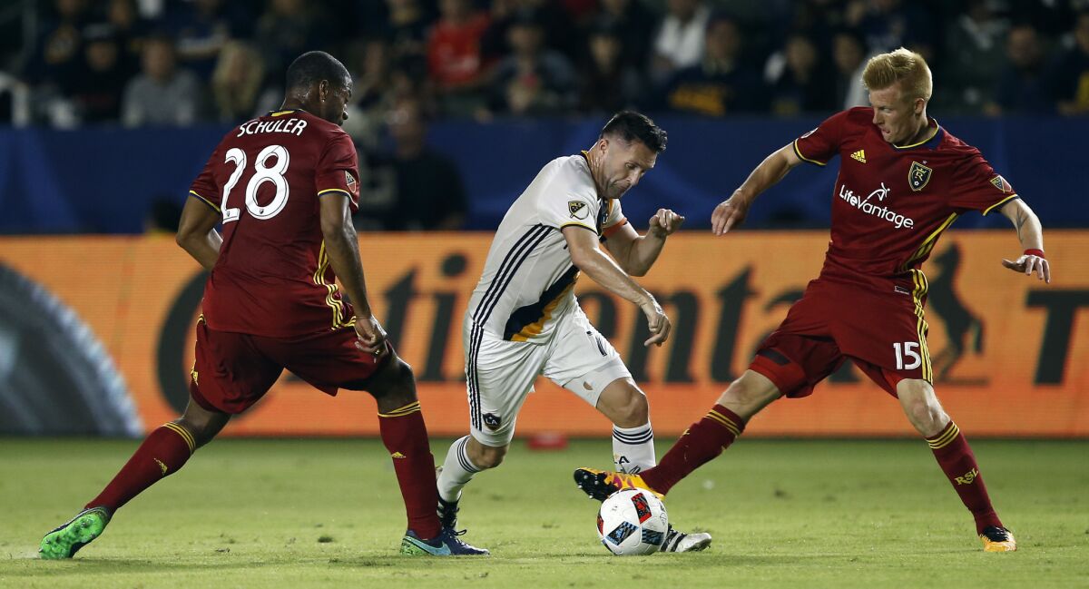 Galaxy forward Robbie Keane, center, tries to split between Real Salt Lake forward Chris Schuler and defender Justen Glad during the second half of a knockout-round MLS playoff match on Oct. 26.