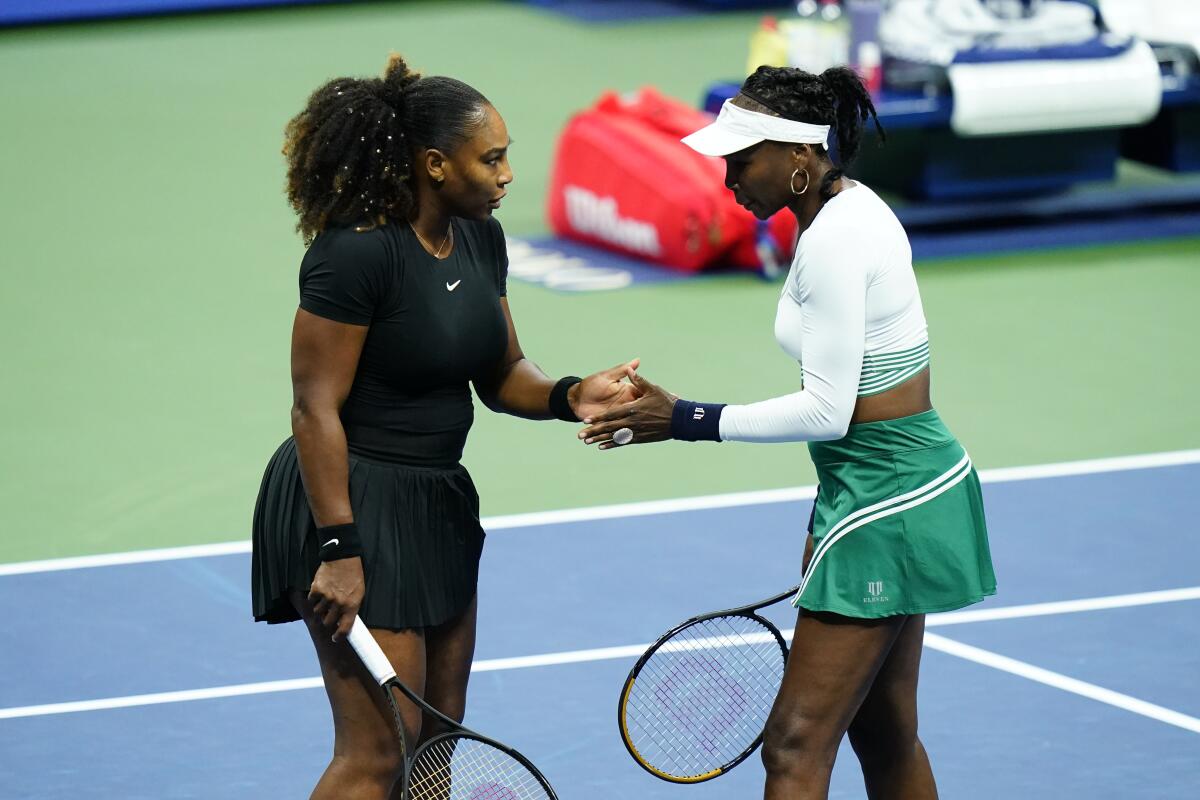 Serena Williams, left, and Venus Williams during their first-round doubles match.