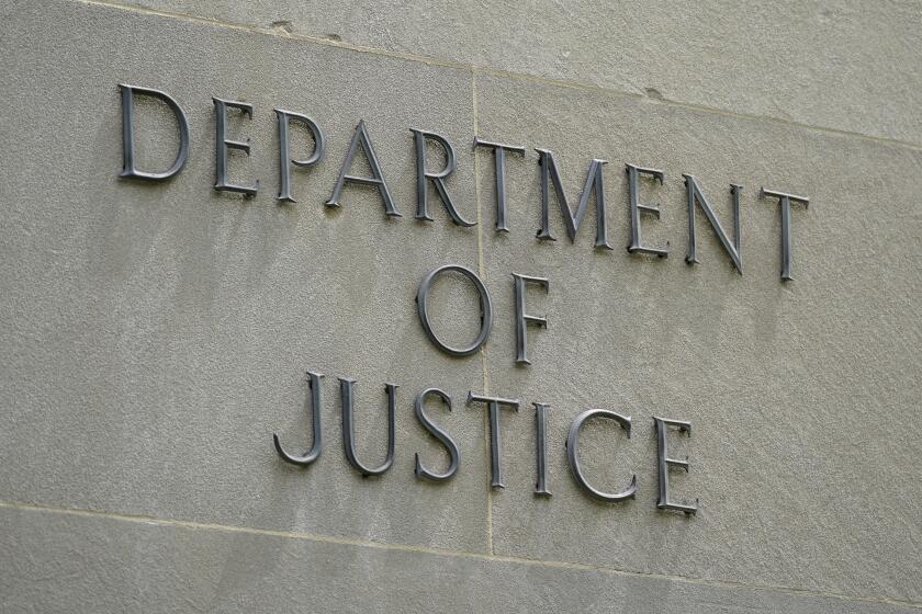 This May 4, 2021, photo shows a sign outside the Robert F. Kennedy Department of Justice building in Washington. The Trump Justice Department secretly seized the phone records of three Washington Post reporters who covered the federal investigation into ties between Russia and Donald Trump's campaign, the newspaper said Friday, May 7. (AP Photo/Patrick Semansky)