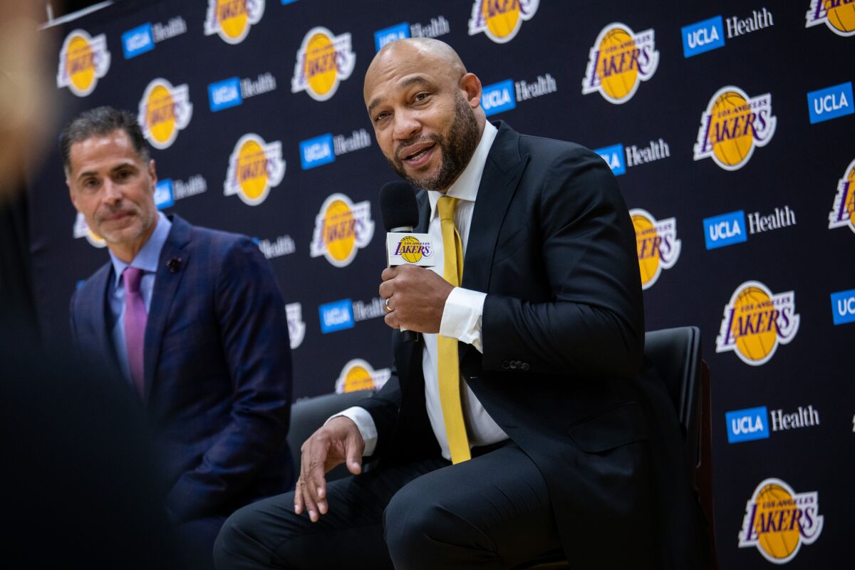 New Lakers coach Darvin Ham holds a microphone while addressing the media Monday.