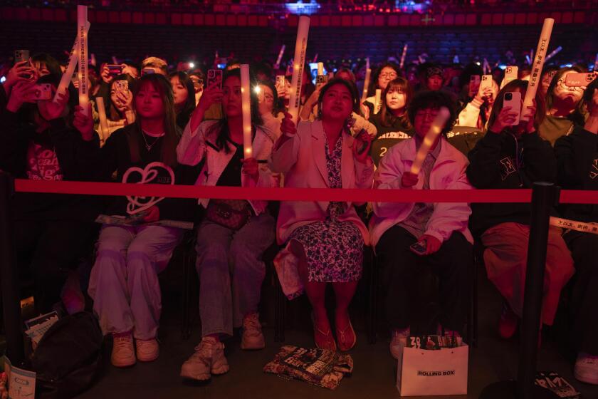 Fans de raperos chinos, incluido Boss X, reaccionan durante una actuación en Chengdu, en la provincia de Sichuan, en el suroeste de China, el sábado 16 de marzo de 2024. El rapero inició haciendo música en un apartamento en ruinas en una antigua comunidad residencial de la ciudad se presenta ahora en estadios ante miles de personas. (Foto AP/Ng Han Guan)