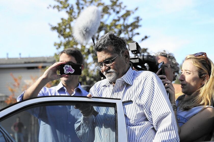 Syed Farook, father of one of the San Bernardino shooters, arrives home to a media swarm in Corona, Calif.