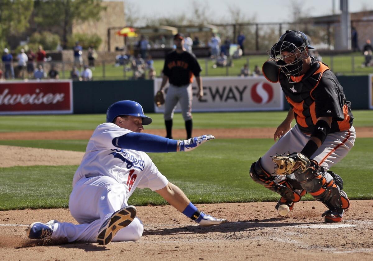 Tim Federowicz, left, scores as San Francisco Giants catcher Guillermo Quiroz bobbles the throw during a spring training game last month.