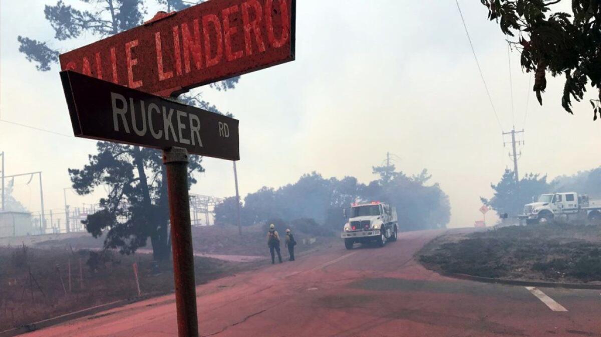 Rucker Road is covered in fire retardant as crews from multiple agencies fight a wildfire in the Mission Hills area of Lompoc, Calif.