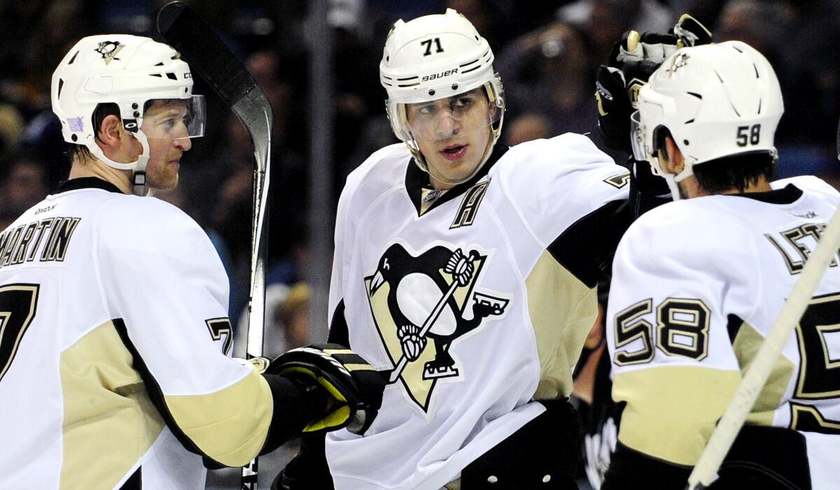 Penguins center Evgeni Malkin, center, is congratulated by defensemen Paul Martin (7) and Kris Letang (58) after scoring against the Sabres during a game Saturday night in Buffalo.