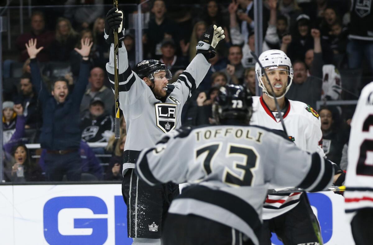 Kings center Jeff Carter celebrates his overtime goal with center Tyler Toffoli, front, who recorded an assist, while Blackhawks defenseman Niklas Hjalmarsson, right, reacts.