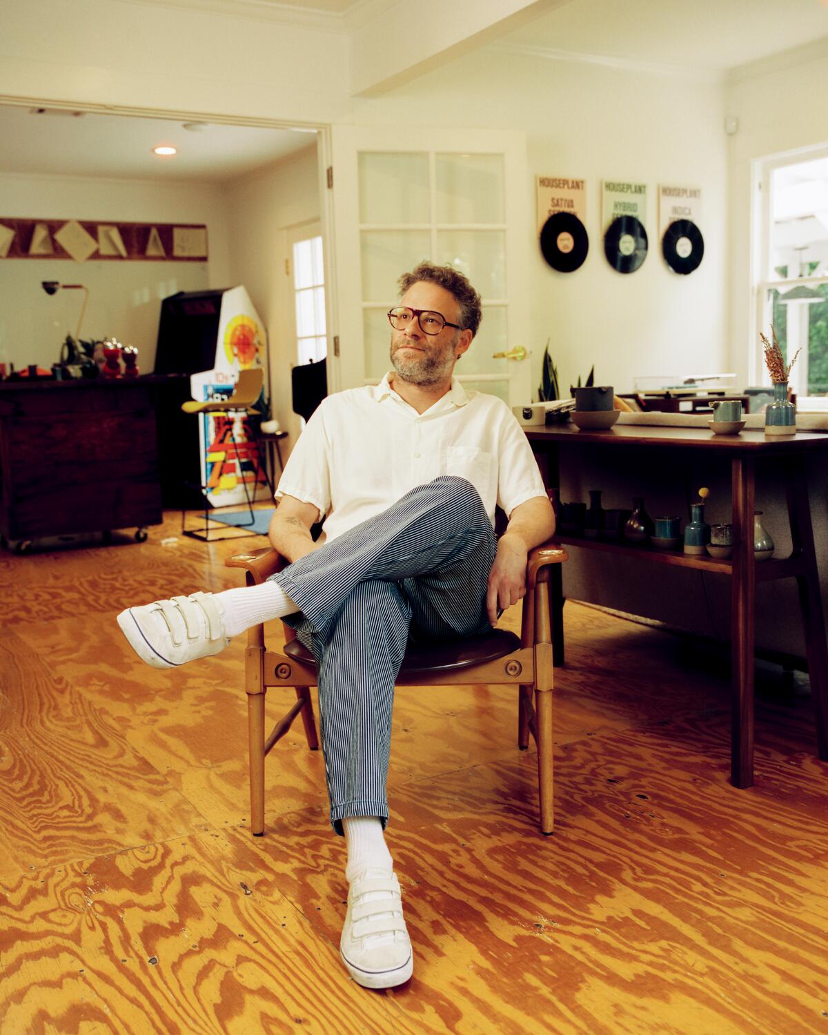 A man sitting in an armchair with his legs crossed.