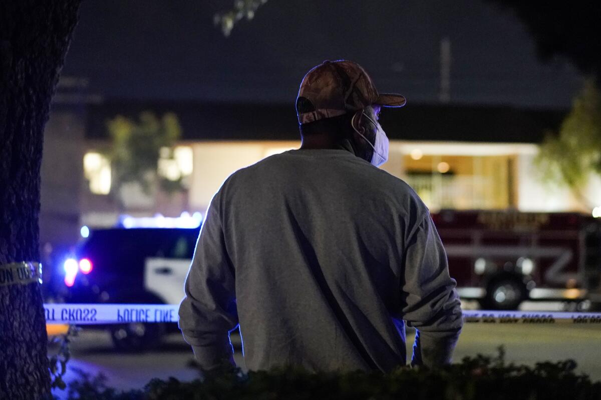 Residents watch as police respond to the scene of a mass shooting in Orange.