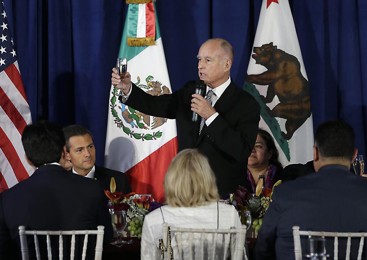 Gov. Jerry Brown, right, makes a toast to Mexican President Enrique Peña Nieto, second from left, during a luncheon held in his honor at the Leland Stanford Mansion in Sacramento on Tuesday.