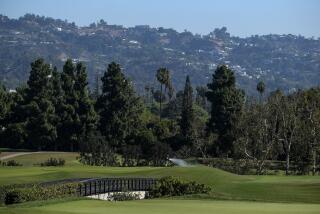 A worker waters the 16th hole during the First Look for the U.S. Open Championship.