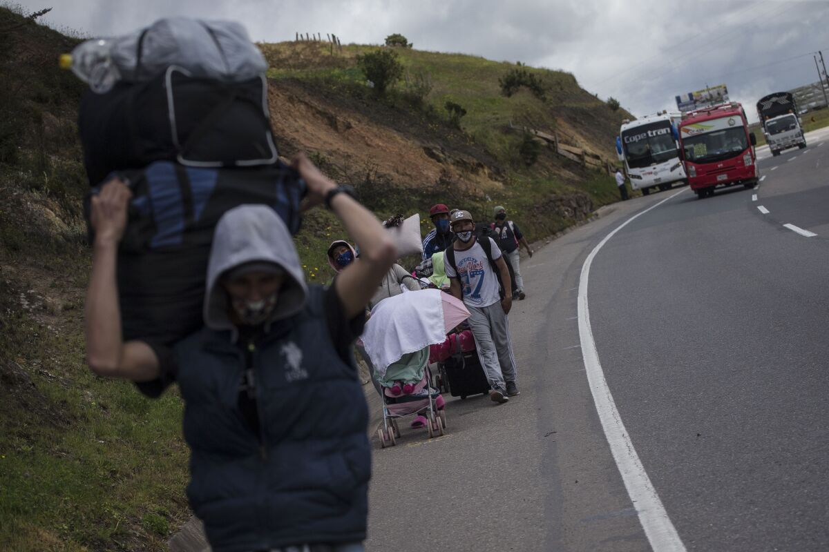 Migrantes venezolanos que caminan hacia Bogotá a su paso por Tunja, Colombia, el 6 de octubre de 2020. Miles de venezolanos se marchan a Colombia, Ecuador y Perú en busca de trabajo coincidiendo con la reapertura de estas economías tras meses de cuarentena contra el coronavirus. (AP Foto/Iván Valencia)