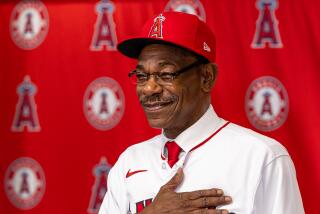 Angels new manager Ron Washington places his hand over his heart as he shows off his new Angels jersey.