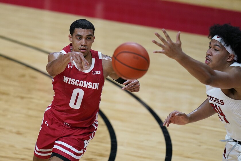 Wisconsin's D'Mitrik Trice, left, passes the ball past Rutgers' Ron Harper Jr. during the first half of an NCAA college basketball game Friday, Jan. 15, 2021, in Piscataway, N.J. (AP Photo/Seth Wenig)