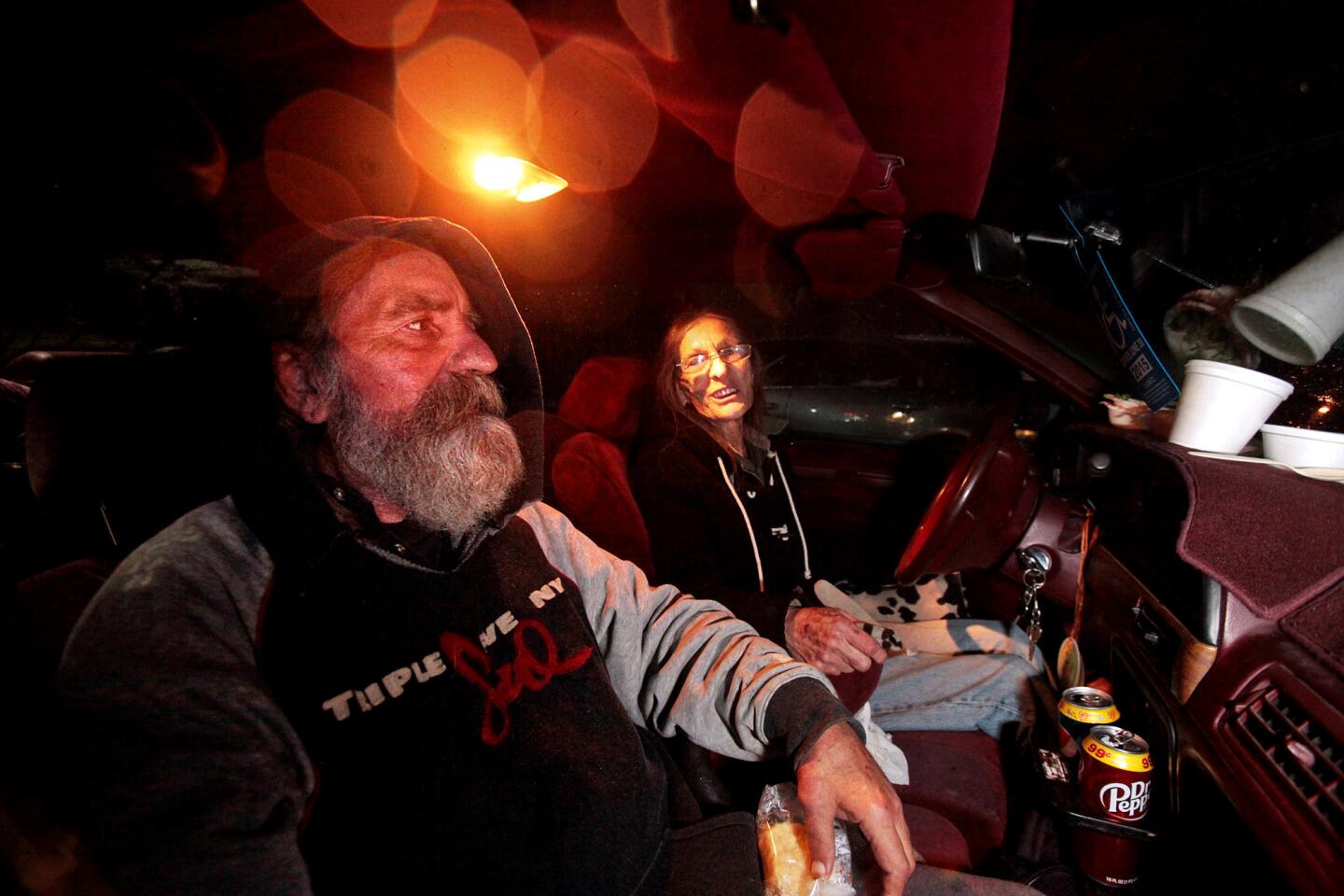 Brother and sister Addison Dorsten, 59, left, and Christine Chapman, 65, eat dinner in their car at the Sonoma County "Safe Parking" lot at the fairgrounds in Santa Rosa.