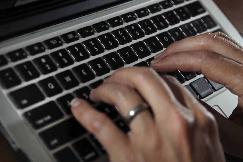 FILE- In this June 19, 2017, file photo, a person types on a laptop keyboard in North Andover, Mass. A new report by a global media consortium that expands the known target list of the Israeli hacker-for-hire firm NSO Group’s military-grade spyware provoked alarm Monday, July 19, 2021, among human rights and press freedom activists. They decried the near-complete absence of regulation of commercial surveillance tools. (AP Photo/Elise Amendola, File)