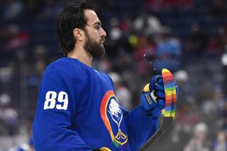 Buffalo Sabres' Alex Tuch wipes off his stick, which is covered with rainbow-colored tape, before an NHL hockey game