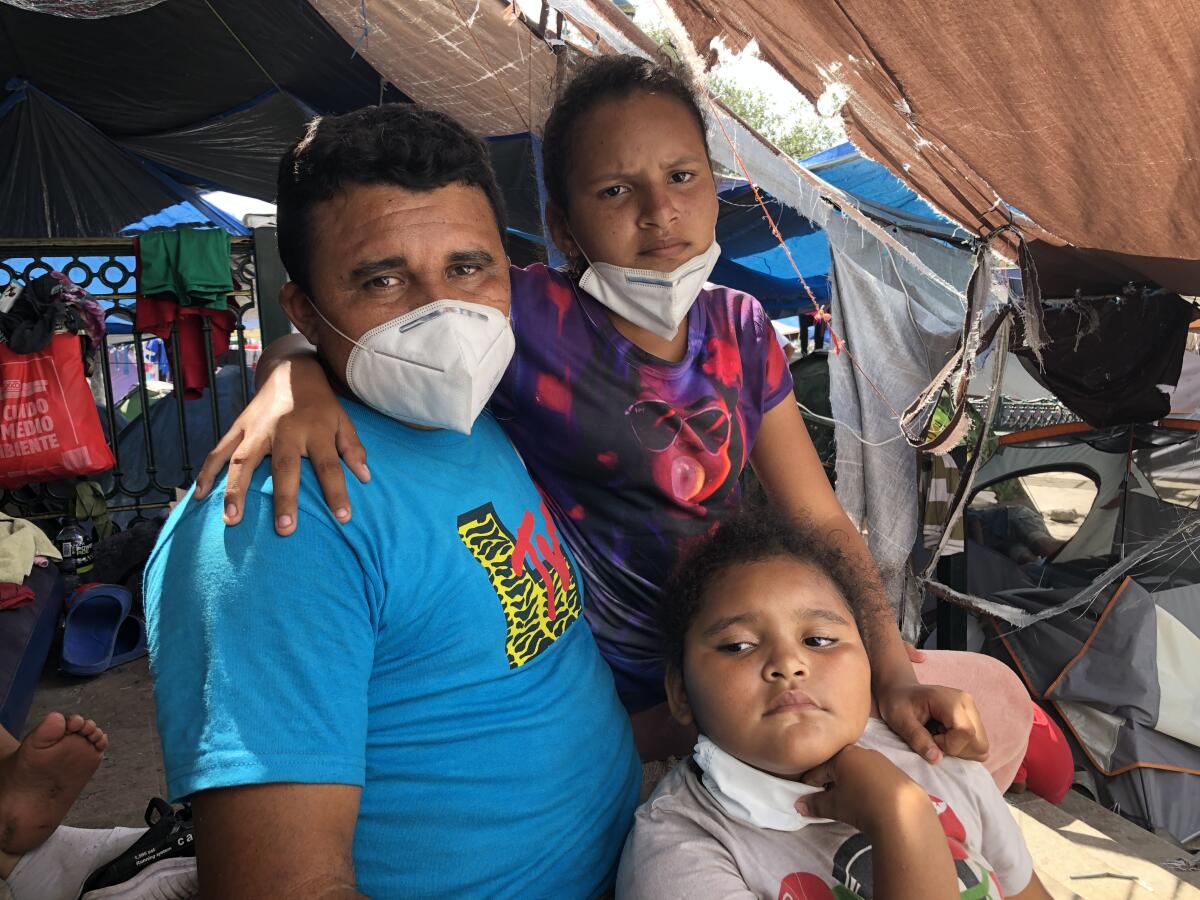 Abel Garcia, an asylum seeker from Honduras, with daughters Andrea, 11, and Ashley, 7, at the Reynosa camp