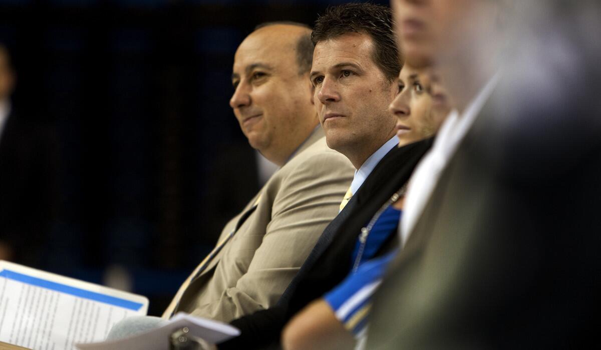 UCLA Athletic Director Dan Guerrero, left, and Steve Alford listen to a speaker during the introduction of Alford as the Bruins' new men's basketball coach on April 2, 2013.