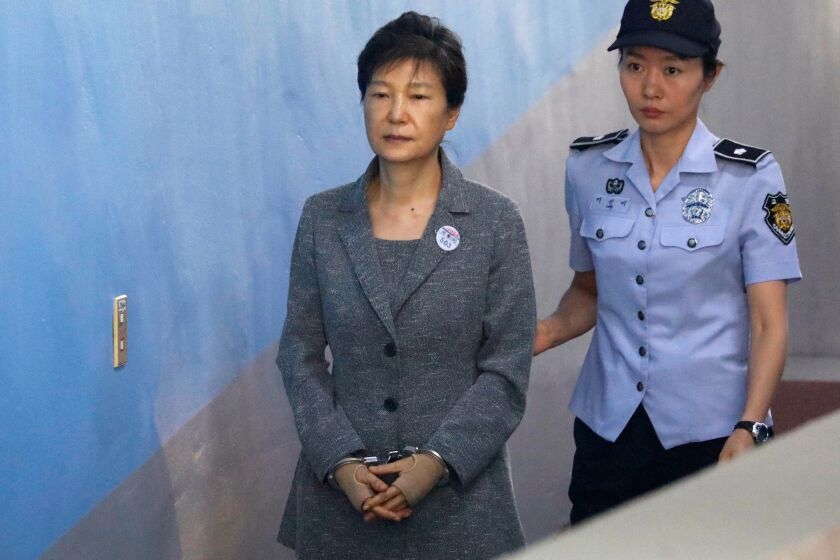 FILE - In this Aug. 25, 2017, file photo, former South Korean President Park Geun-hye, left, arrives for her trial at the Seoul Central District Court in Seoul, South Korea. A South Korean has sentenced disgraced ex-President Park to 24 years in prison over a corruption scandal. The Seoul Central District Court issued the verdict on Friday, April 6, 2018, after convicting Park of bribery, abuse of power, extortion and other charges. Park has been held at a detention center near Seoul since her arrest in March 2017, but she refused to attend Friday’s court session citing sickness. (Kim Hong-Ji/Pool Photo via AP, File)
