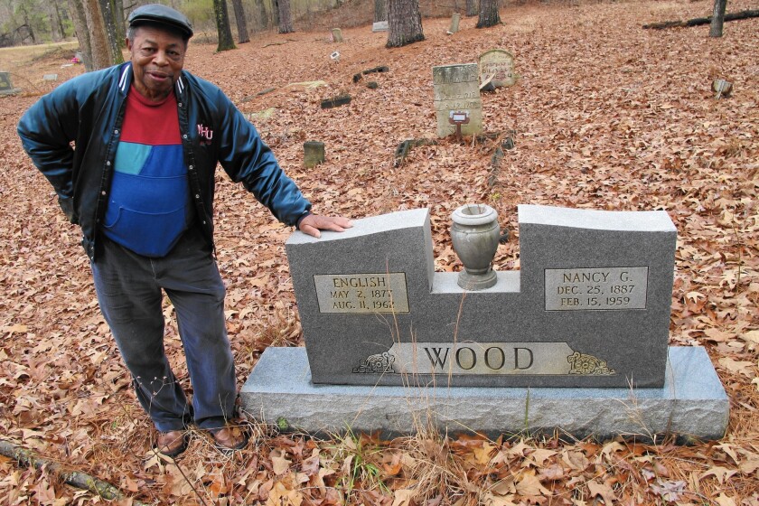 Major Wood stands at the graves of his grandparents in a church cemetery in Lee County, N.C. He worries that if an energy company stores coal ash in a nearby clay mine pit, a leak of the toxic material could threaten the cemetery.
