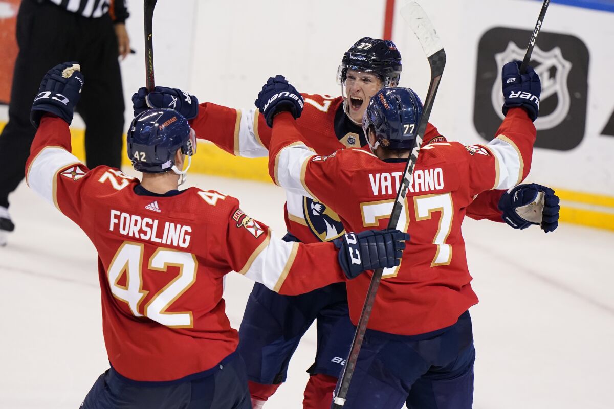 Florida Panthers center Eetu Luostarinen, rear, celebrates with defenseman Gustav Forsling (42) and center Frank Vatrano (77) after scoring the winning goal during an overtime period of an NHL hockey game against the Washington Capitals, Thursday, Nov. 4, 2021, in Sunrise, Fla. (AP Photo/Wilfredo Lee)