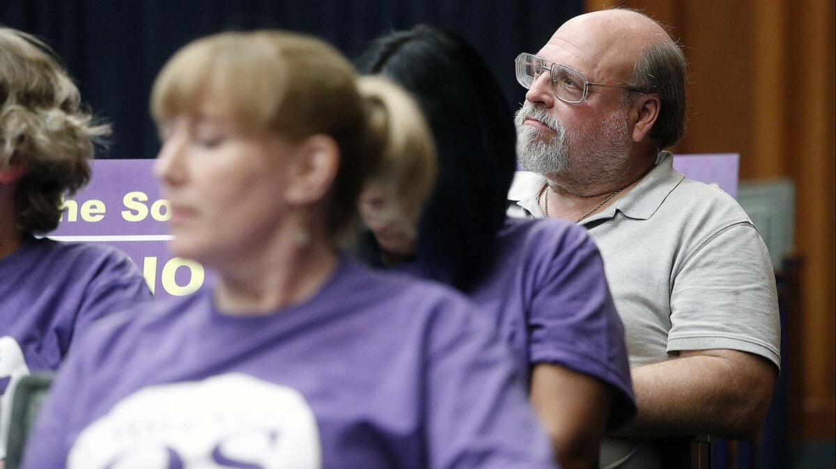 Measure QS opponent Larry Applebaum sits behind a group of Measure QS supporters at the Burbank Unified board meeting in council chambers at Burbank City Hall on Oct. 18. Public comment during the meeting focused on the Measure QS issue.