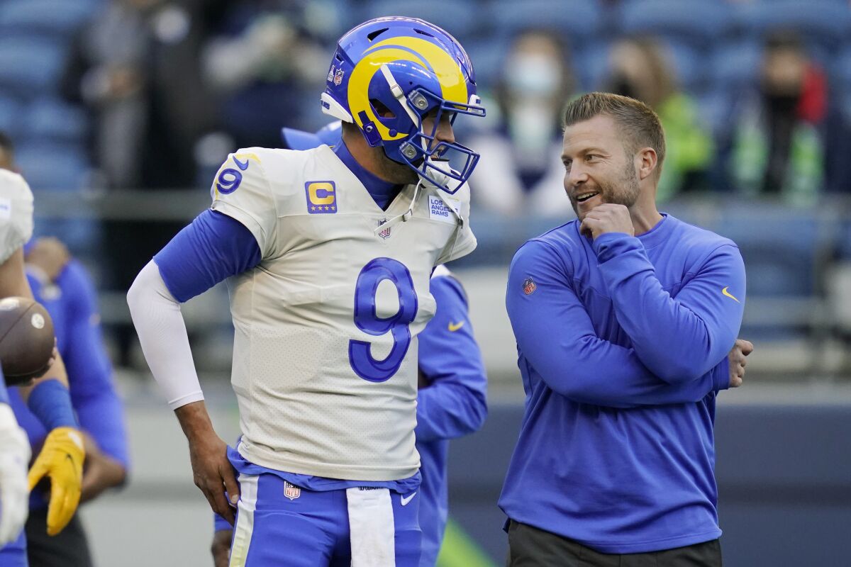 Los Angeles Rams quarterback Matthew Stafford (9) talks with head coach Sean McVay before an NFL football game against the Seattle Seahawks, Thursday, Oct. 7, 2021, in Seattle. (AP Photo/Elaine Thompson)