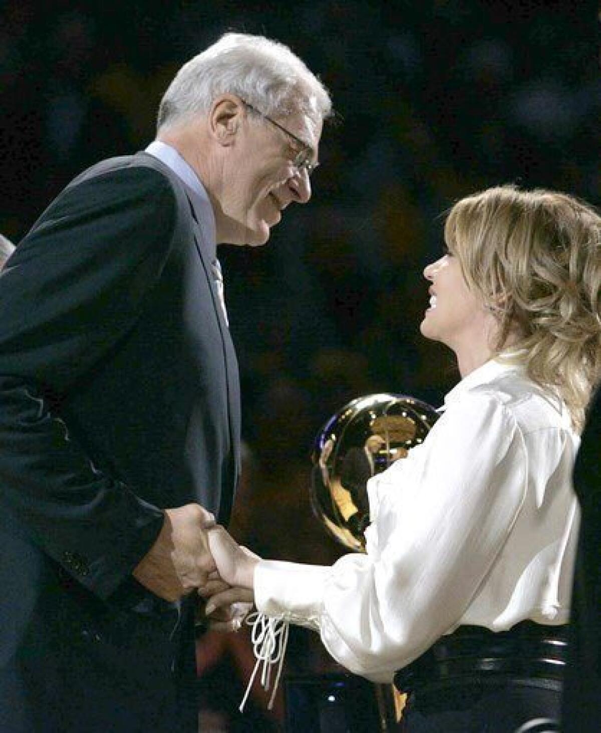 Phil Jackson accepts his 2009 NBA championship ring from Jeanie Buss before the 2009-10 season opener against the Clippers at Staples Center.