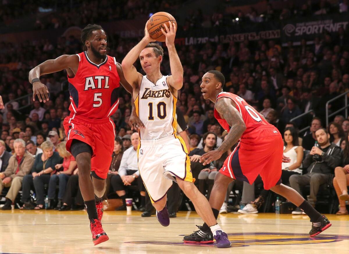Lakers guard Steve Nash, center, drives between Atlanta Hawks forward DeMarre Carroll, left, and guard Jeff Teague during the first half of Sunday's game at Staples Center.