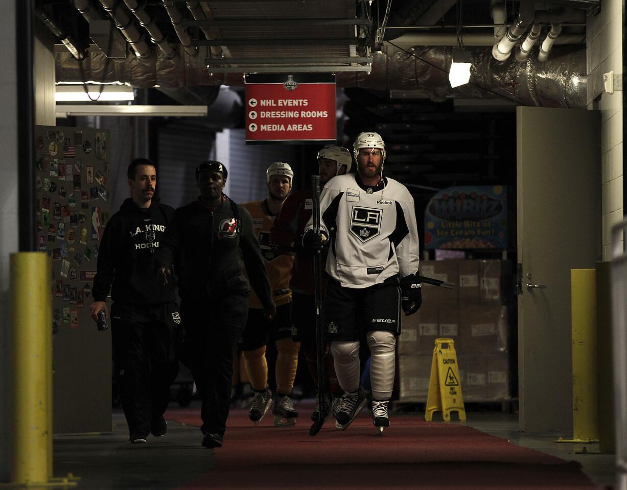 Jeff Carter, right, heads to the ice to take part in a team practice session at the Prudential Center in Newark, N.J., on Friday. The Kings play the New Jersey Devils in Game 2 of the Stanley Cup Final on Saturday.