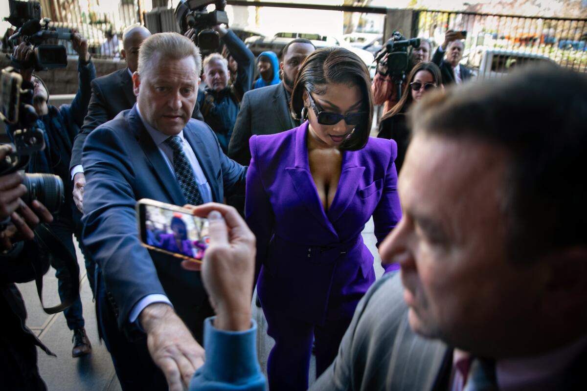 Megan Thee Stallion arrives at court with people around her.