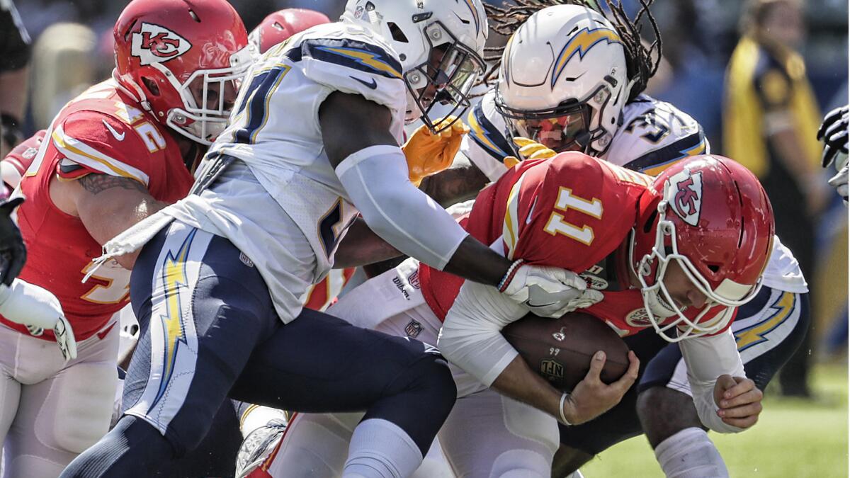 Chargers defenders tackle Chiefs quarterback Alex Smith during a first half drive.