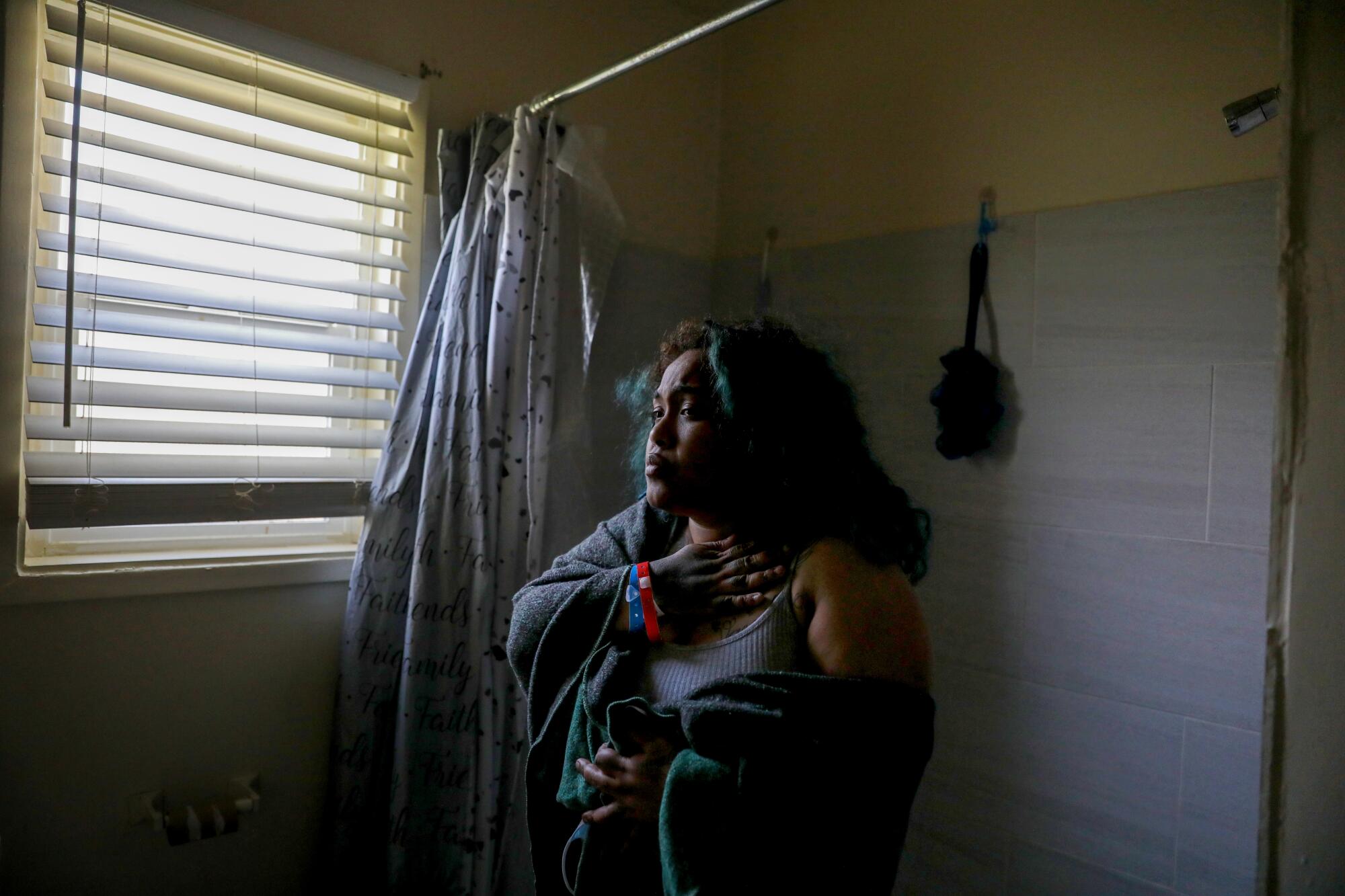 Sabrina Dolan looks out a window in her unit at Chesapeake Apartments in South L.A.