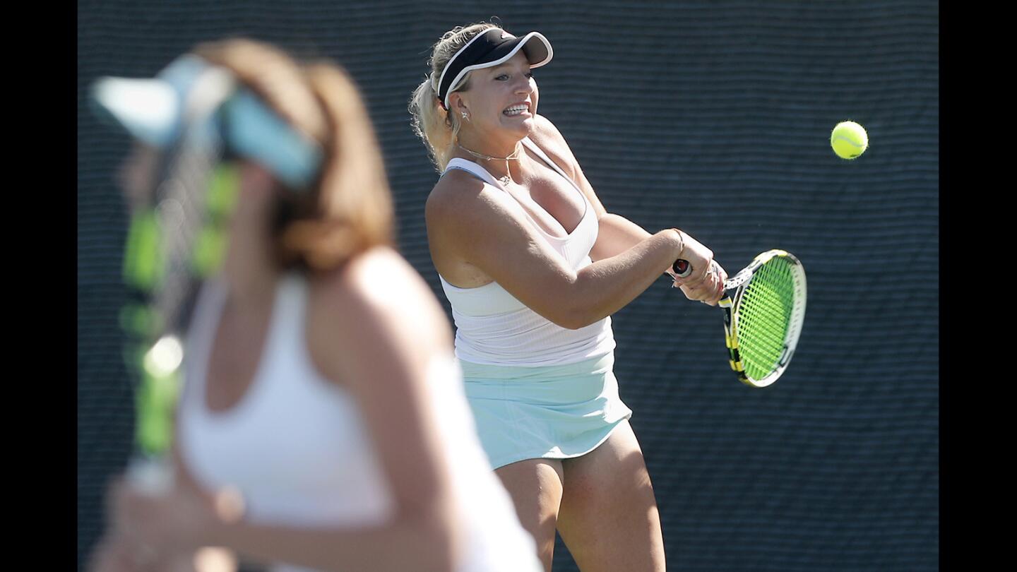 Corona del Mar High No. 1 doubles player Kristina Evloeva hits the ball as partner Roxy MacKenzie, left, covers the net against Los Alamitos during the second day of the Surf League girls' tennis finals at Seal Beach Tennis Center on Thursday, Oct. 25.