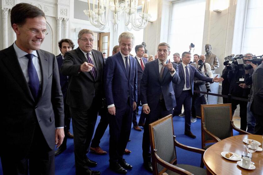 Dutch Prime Minister Mark Rutte, left, and Geert Wilders, center, of the far-right Freedom Party arrive for a meeting between main party leaders and the chairman of the Senate in The Hague one day after the general elections.