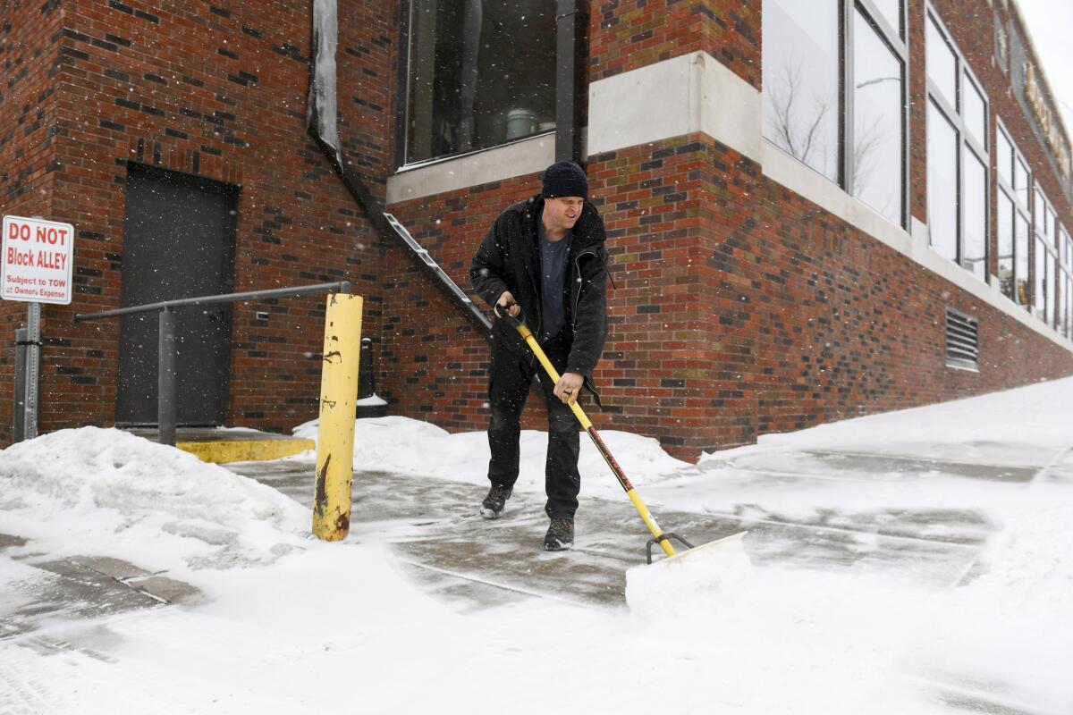 David Smith shovels the sidewalk in Sioux Falls, S.D. 