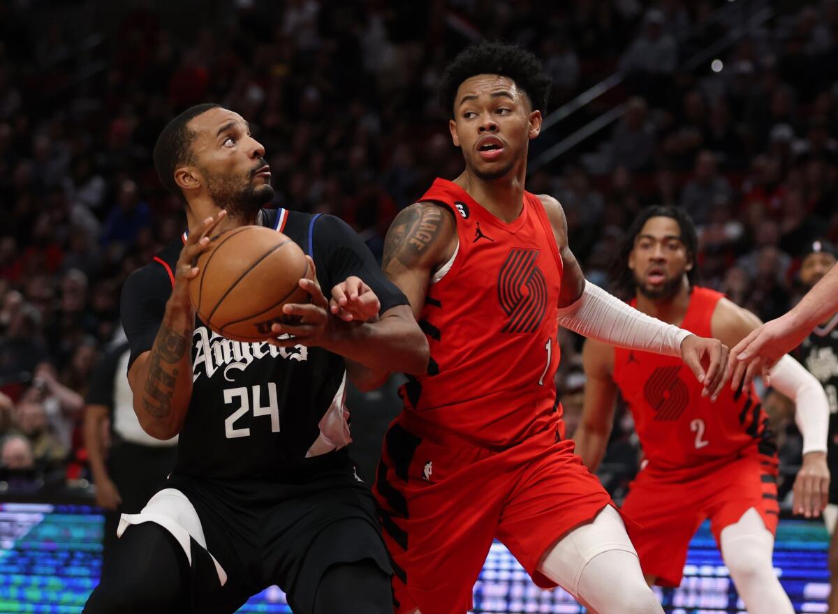 Clippers forward Norman Powell looks to shoot as Portland Trail Blazers guard Anfernee Simons defends.