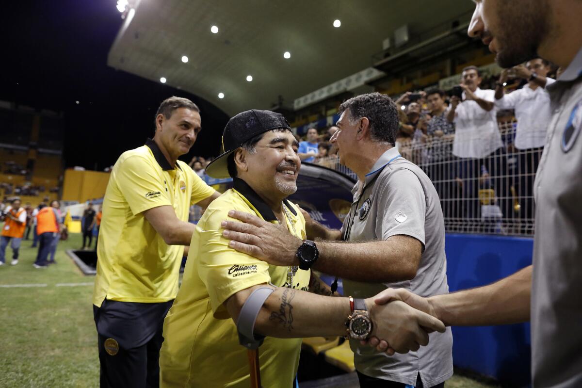 Dorados of Sinaloa coach Diego Maradona, second from left, greets opposing coaches before the start of a game against Tampico Madero in Culiacán, Sinaloa, on Oct. 27.