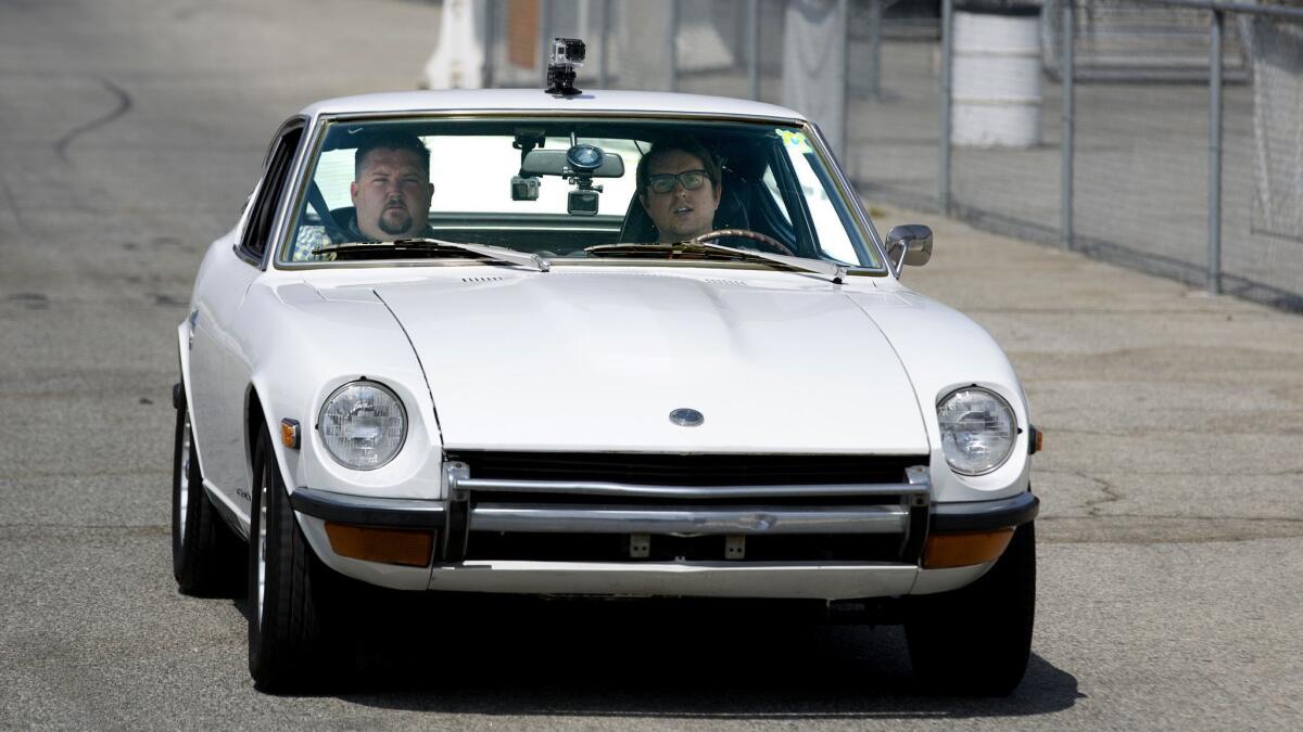 Reporter Daniel Miller, right, recording sound — while getting some drag-racing instruction — at Irwindale Speedway for "Larger Than Life."