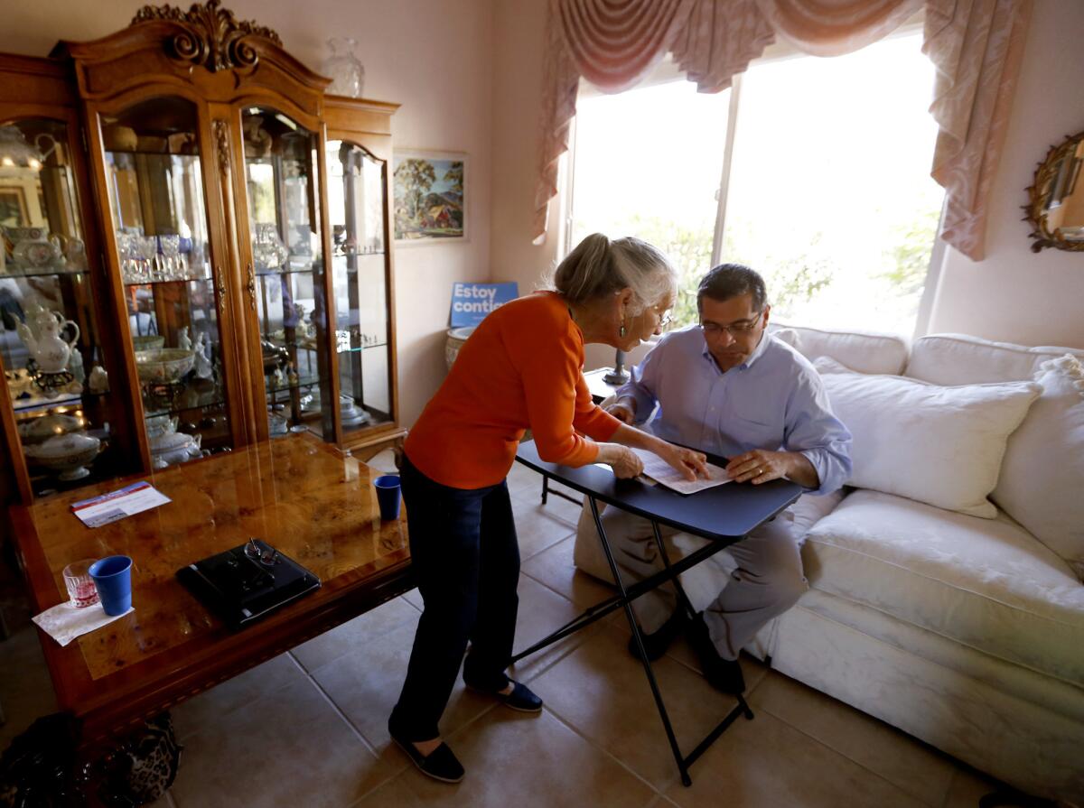 LAS VEGAS- Maria Gray, shows Xavier Becerra (CA-34), right, a U.S. Representative of Los Angeles and Chairman of the House Democratic Caucus, a list of phone numbers in her home. Xavier made calls on behalf of the Hillary Rodham Clinton's presidential campaign at Maria Gray's phone bank in her home. (Francine Orr/ Los Angeles Times)
