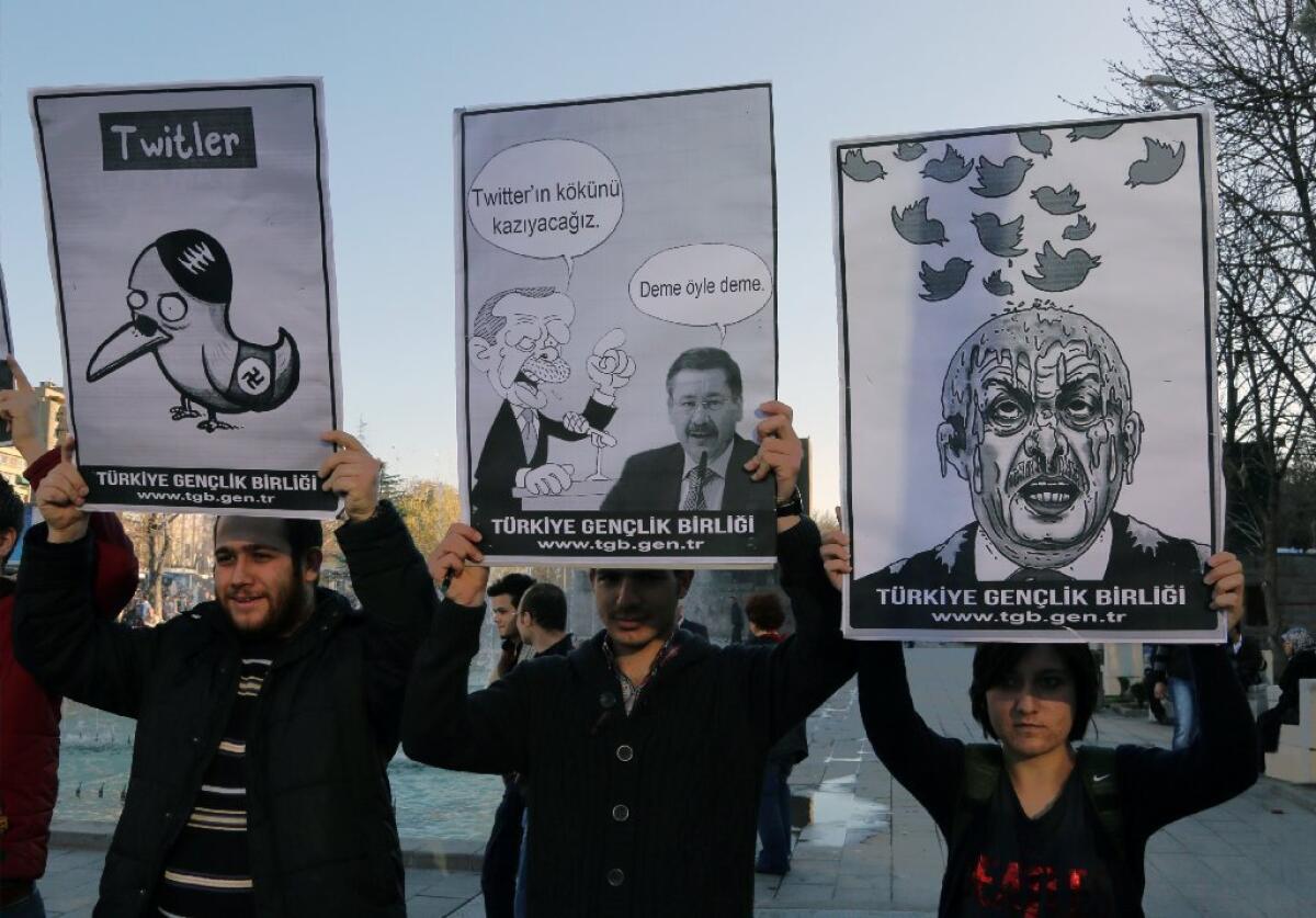 Members of the Turkish Youth Union hold cartoons depicting Turkey's Prime Minister Recept Tayyip Erdogan during a protest in Ankara against the ban on Twitter.