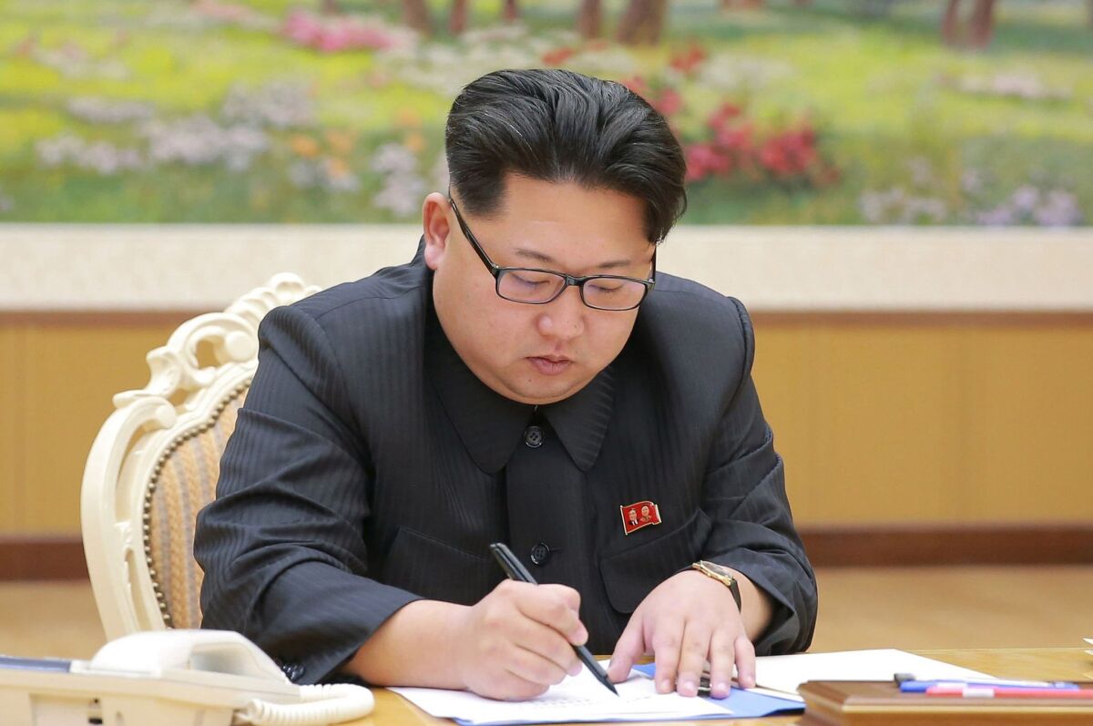 Kim Jong Un signing a document